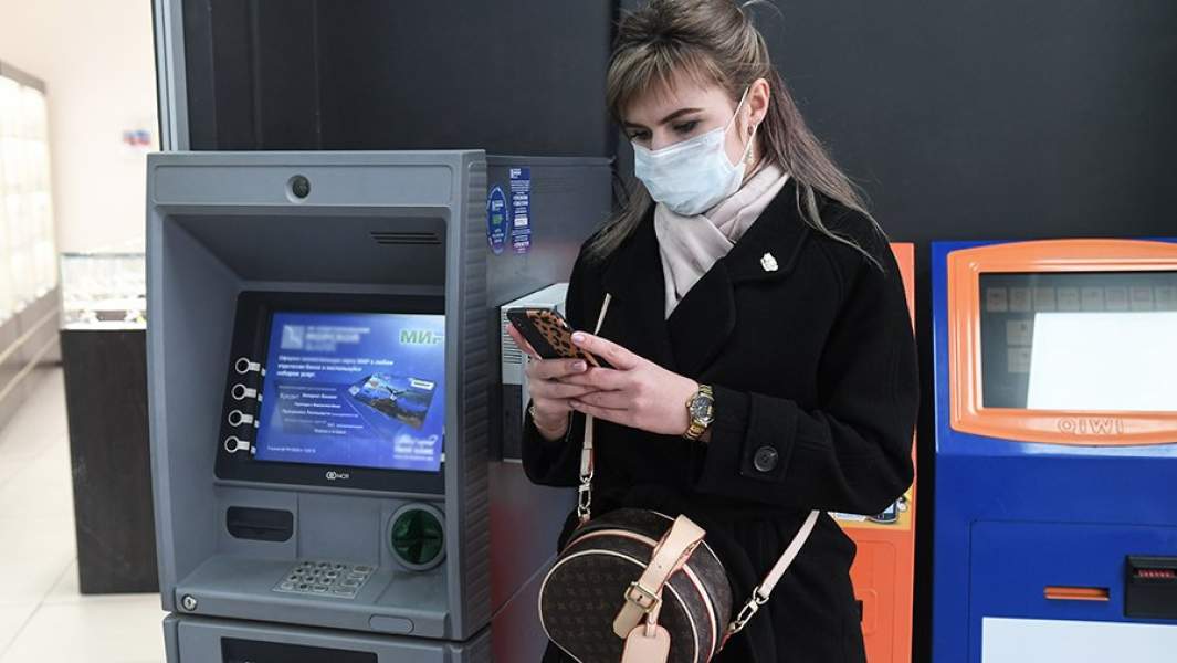 Девушка стоит возле банкомата