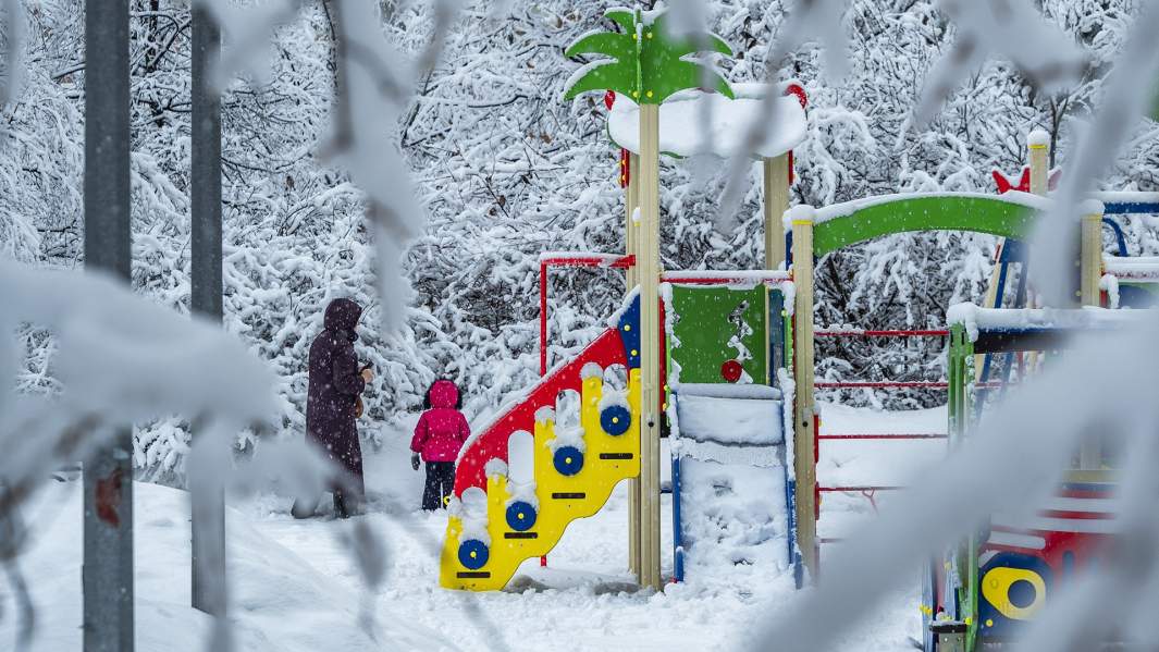 Женщина с ребенком на детской площадке