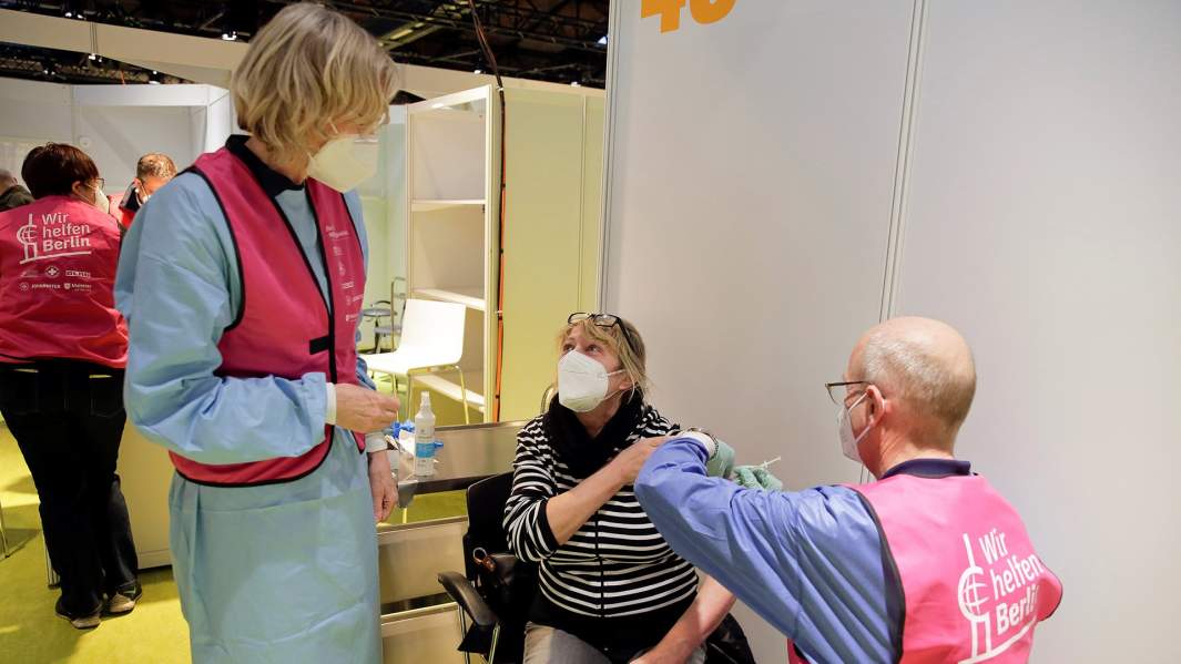 Немецкие медики делают женщине прививку от Covid-19