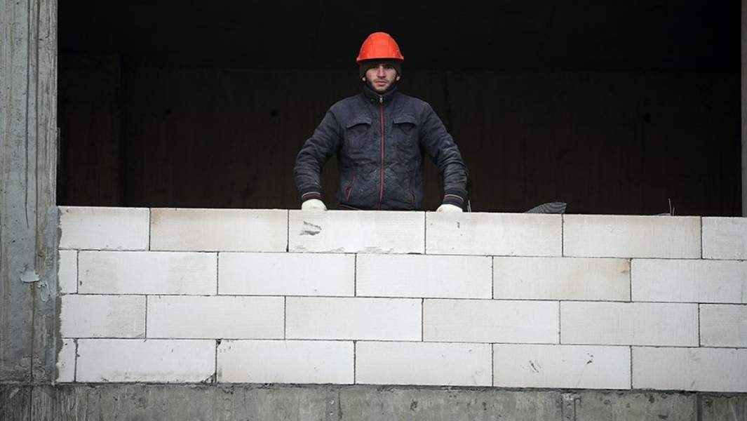Мигрант работает на стройке