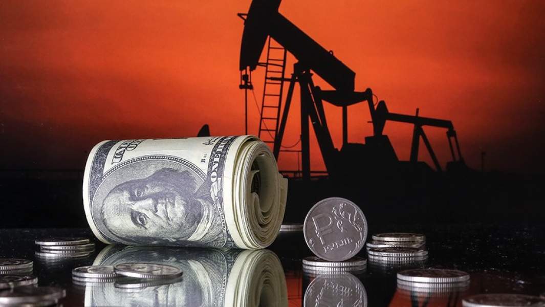 Купюры доллара и монета рубль, нефтяной насос