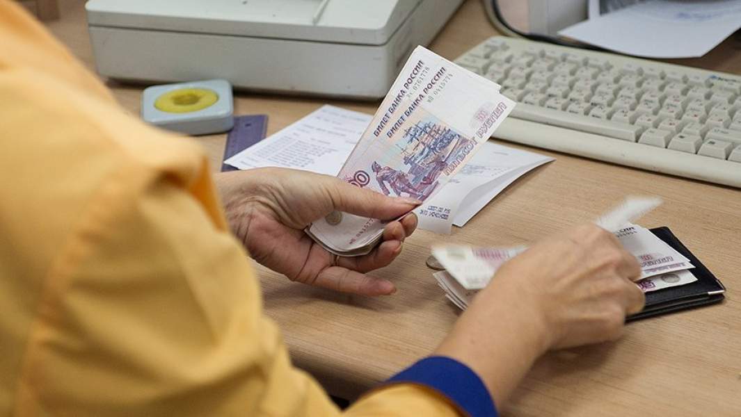 Сотрудница одного из московских отделений «Почты России» выдает ежемесячное денежное пособие