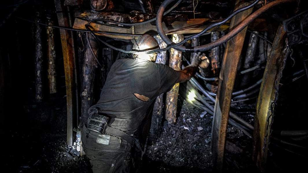 Шахтеры готовят бревна для укрепления штрека на шахте