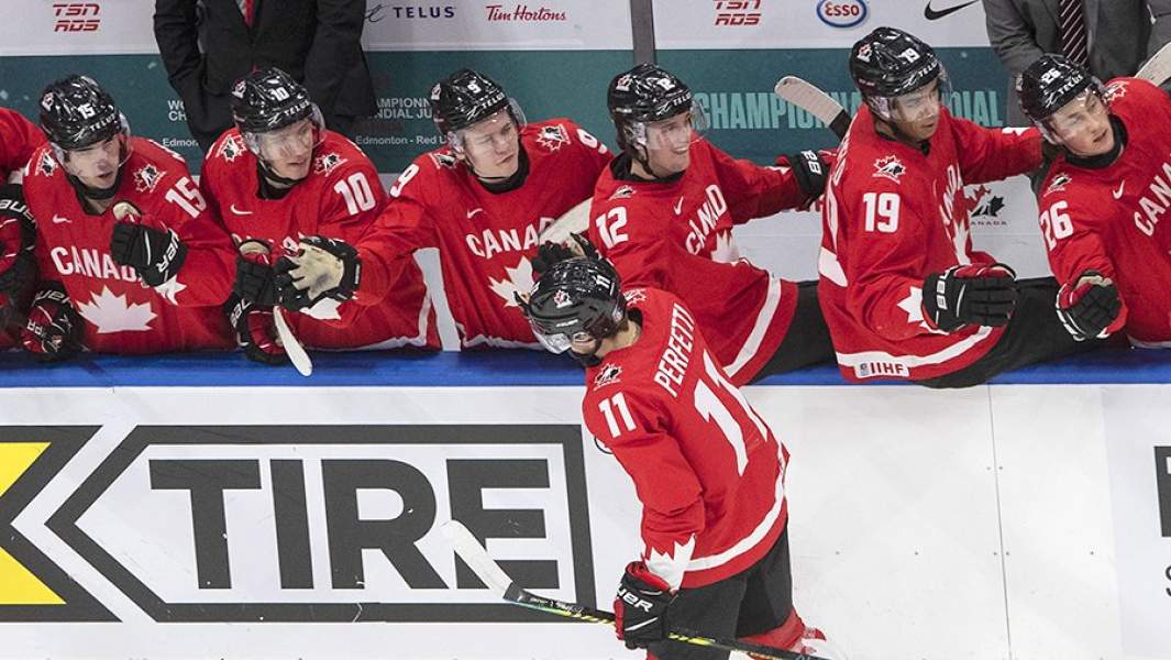 Игрок Канады Кол Перфетти (на первом плане) во время матча 1/2 финала молодежного чемпионата мира по хоккею между сборными России и Канады