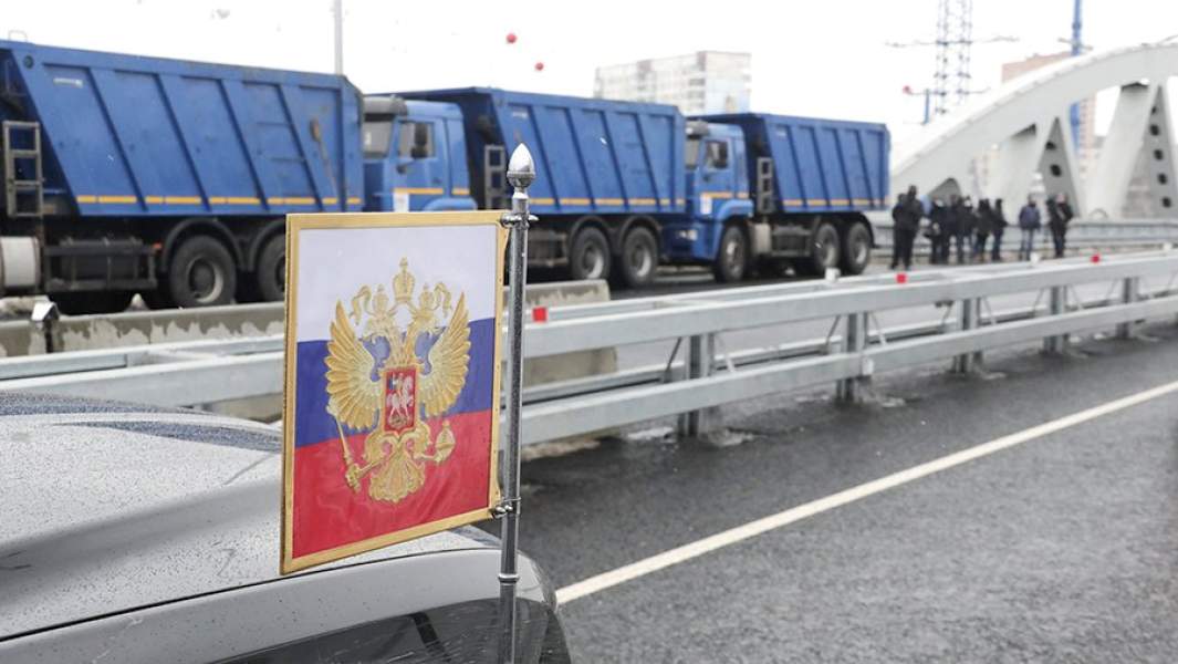 Флажок с гербом на автомобиле президентского кортежа после церемонии открытия транспортной развязки на пересечении автомобильной дороги М-10 «Россия» и улицы Репина