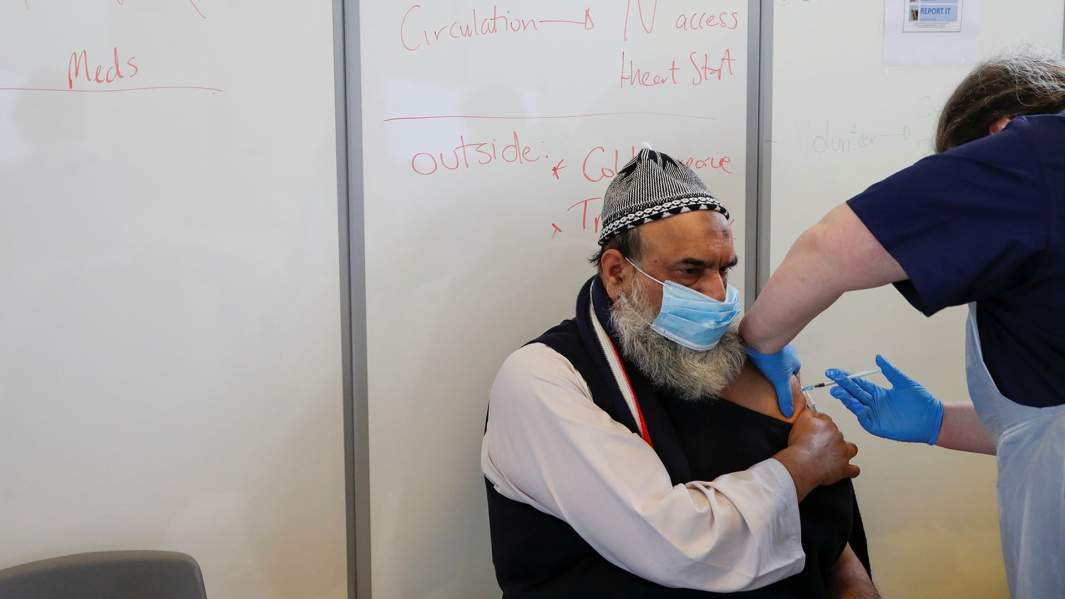 мужчине делают прививку от коронавируса в Бедфорде