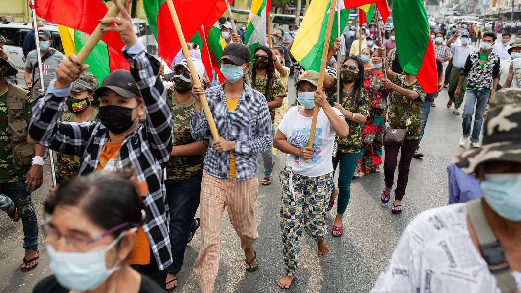 Люди с флагами маршируют по улицам, протестуя против результатов выборов в Бирме