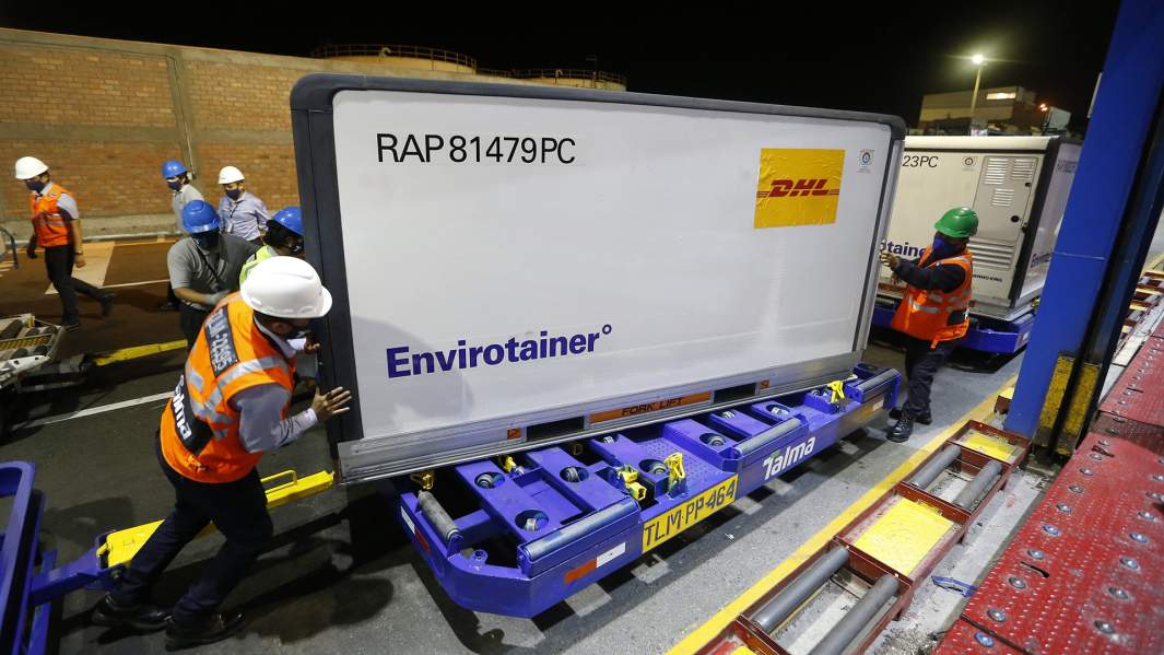 Рабочие грузят в аэропорту партию вакцины от китайской фармацевтической компании 