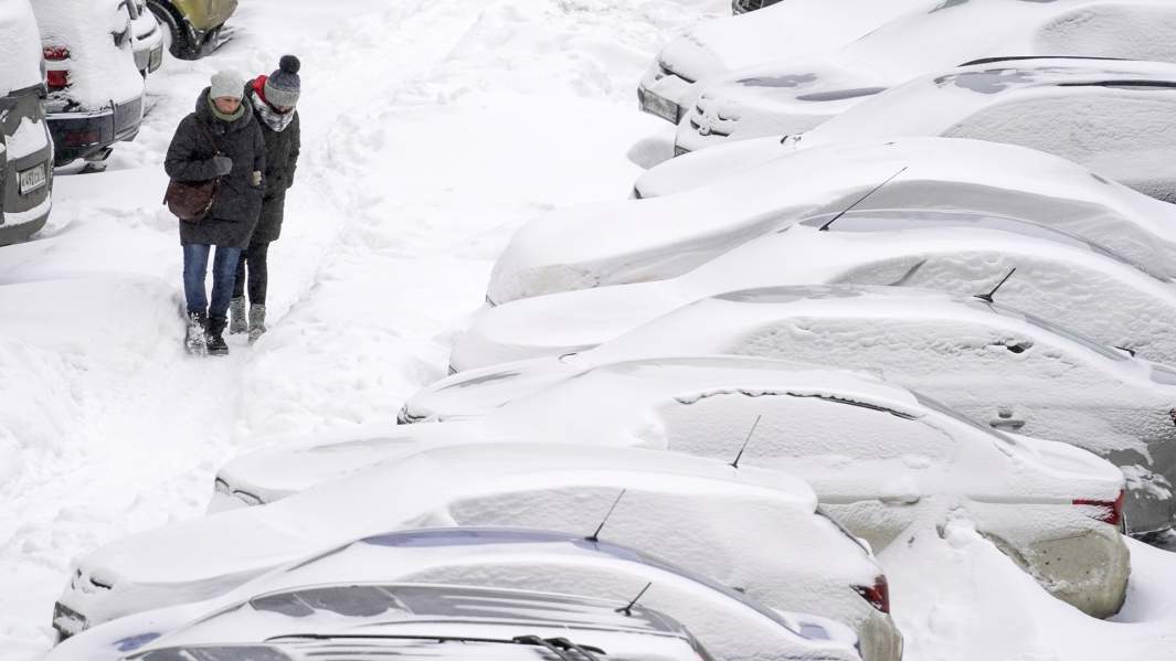 Засыпанные снегом машины на стоянке