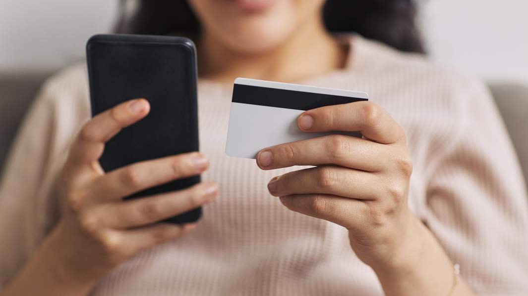девушка с кредитной картой и телефоном в руках