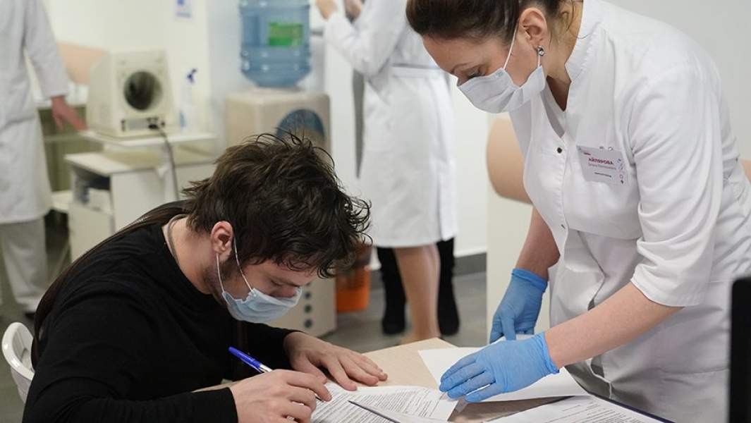 Пациент заполняет документ перед вакцинированием