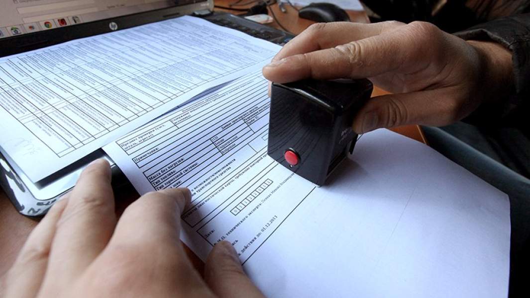 Сотрудник передвижного пункта технического осмотра оформляет диагностическую карту