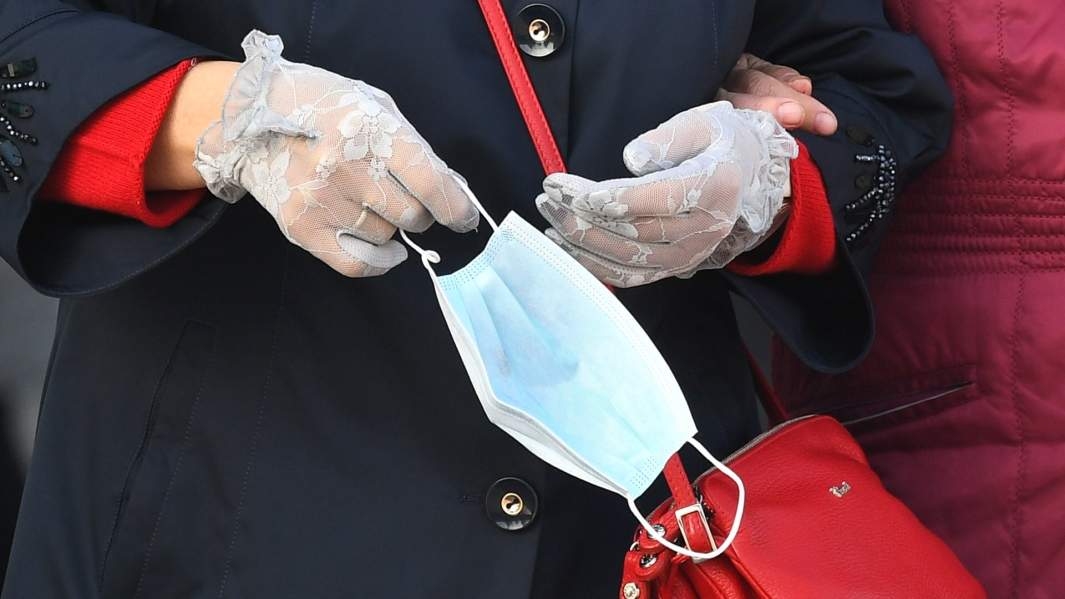 защитная маска в руках женщины