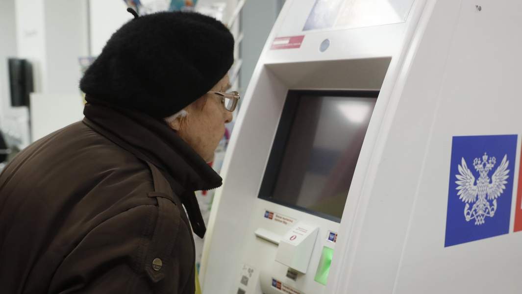 пенсионерка осуществляет платеж в банкомате