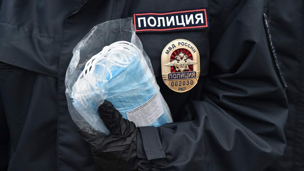 пачка медицинских масок в руках полиции