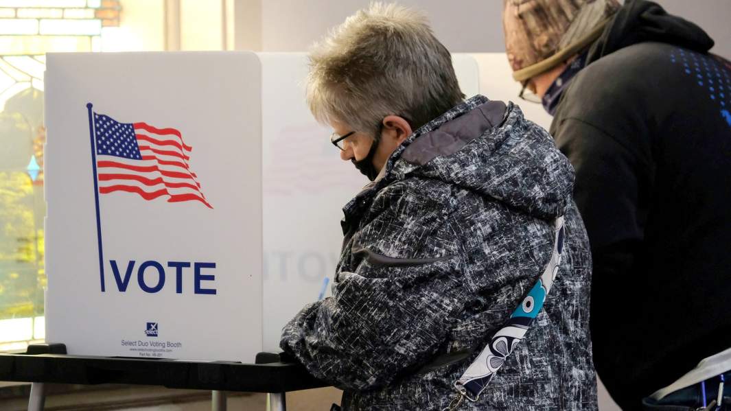 Люди заполняют бюллетени в кабине для голосования во время президентских выборов 2020 года в США 