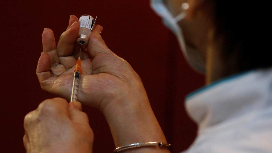 медсестра в Сингапуре набирает в шприц вакцину от коронавируса
