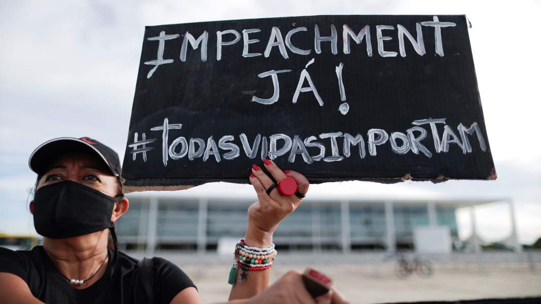 Протестующая держит табличку с надписью «Импичмент, сейчас!» в Бразилии