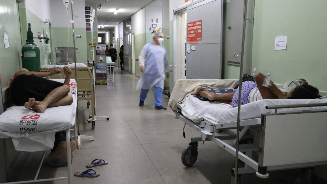 Пациенты с подтвержденным COVID-19 ждут очереди в коридоре для перевода в отделение интенсивной терапии в Сан-Паулу