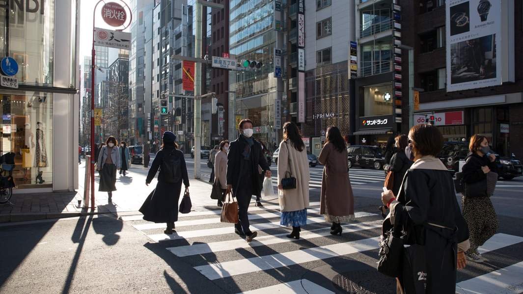 Люди в масках на улице в Токио