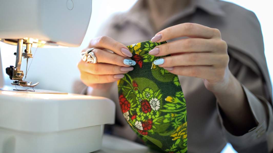 Девушка дома шьёт на заказ защитные маски