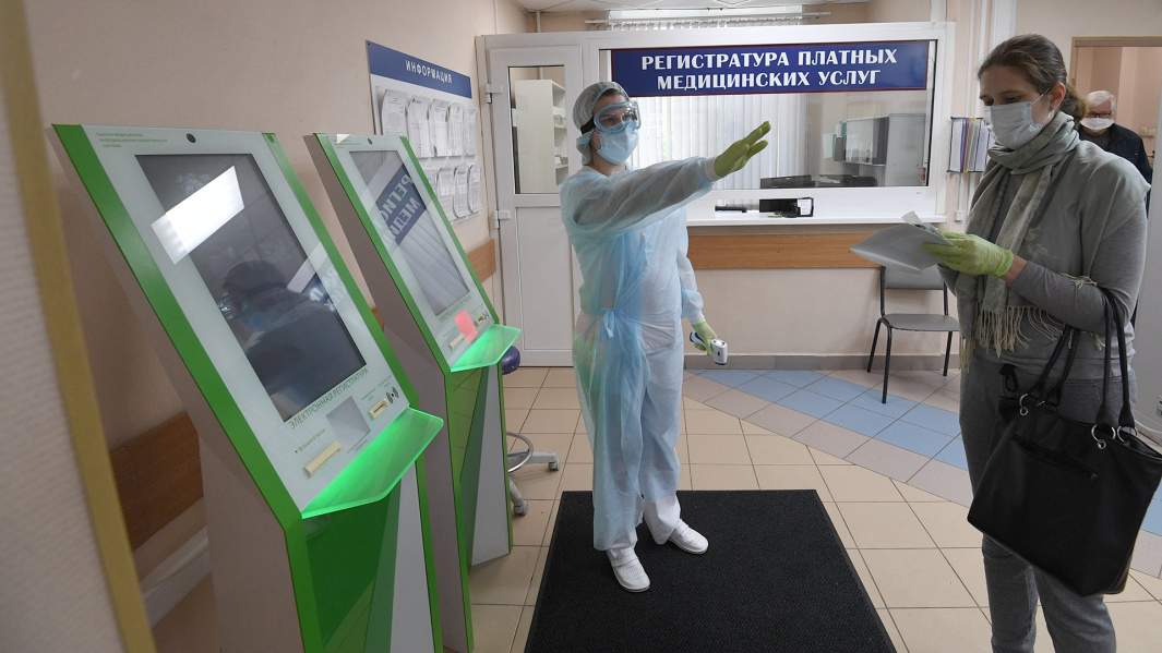 Девушка после измерения температуры при входе в лечебное учреждение и перед сдачей анализа на антитела к коронавирусу COVID-19 в городской поликлинике № 209 в Москве