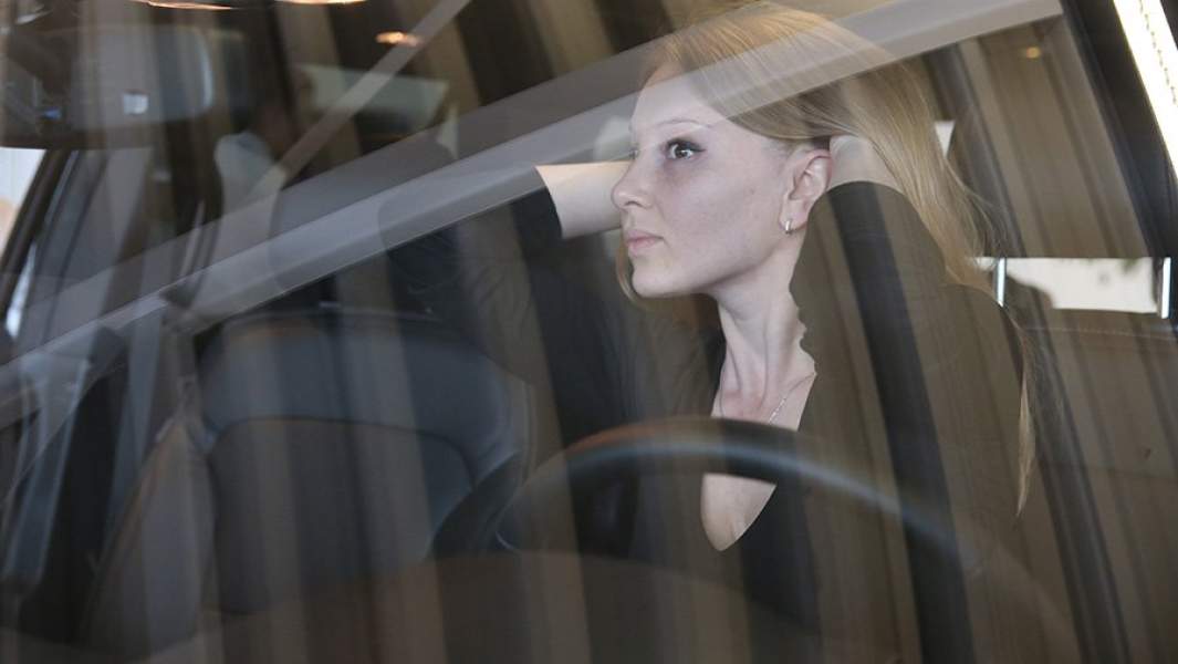 Девушка в автомобиле в дилерском центре продаж