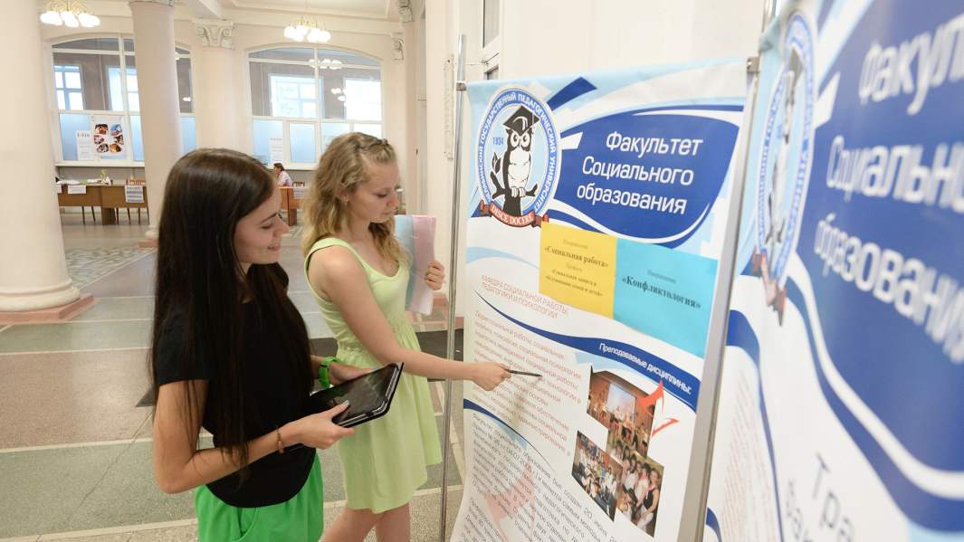 Абитуриентки изучают информацию на стенде перед подачей документов для поступления в Челябинский государственный педагогический университет