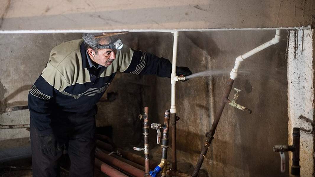 Рабочий регионального фонда капитального ремонта многоквартирных домов ремонтирует отопительную систему