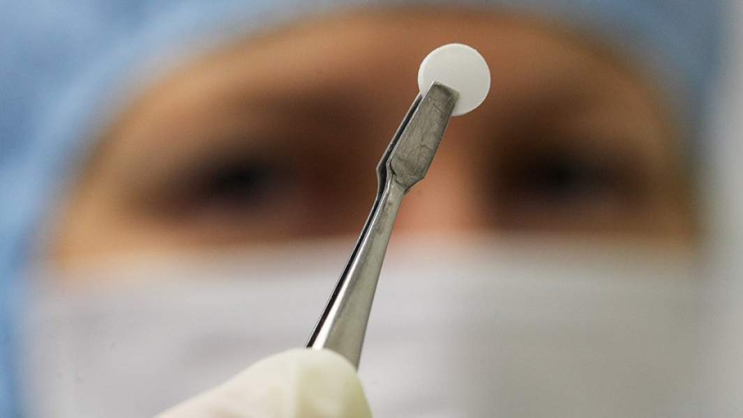 Сотрудница демонстрирует продукцию в одном из цехов фармацевтического завода