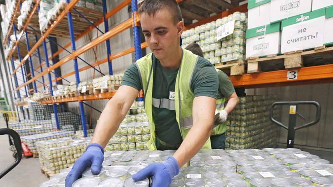 Молодой человек работает на складе