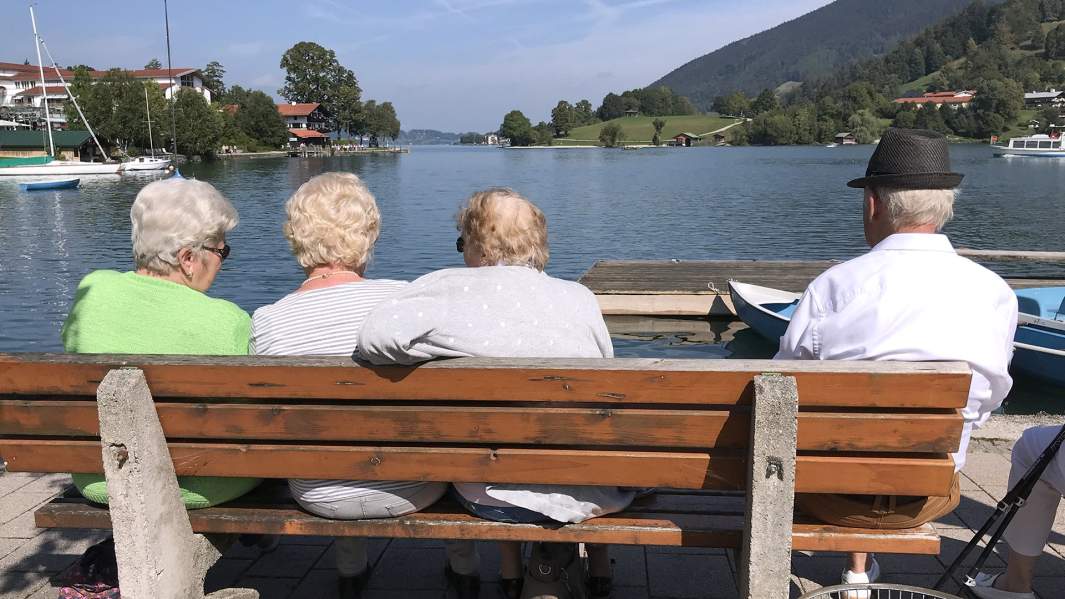 люди пожилого возраста сидят на скамейке в Германии
