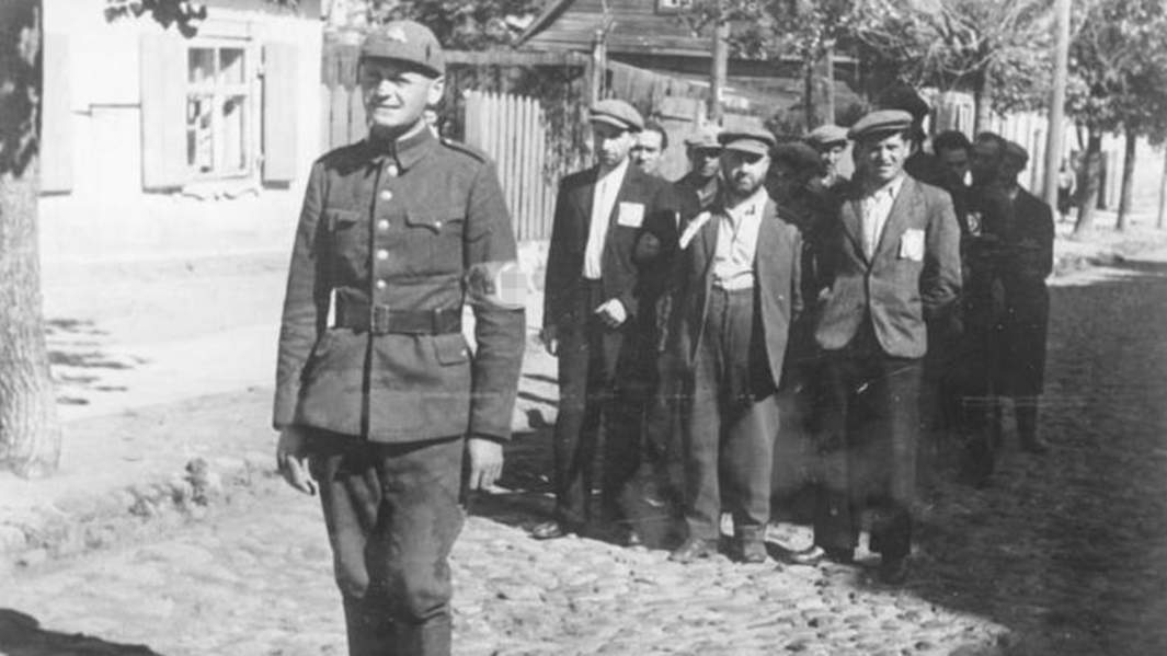 Литовский полицейский сопровождает группу литовских евреев