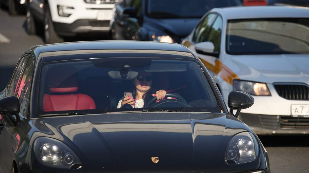 девушка с телефоном за рулем автомобиля