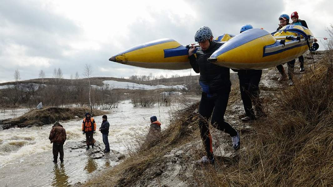 Спортсмены несут катамаран 