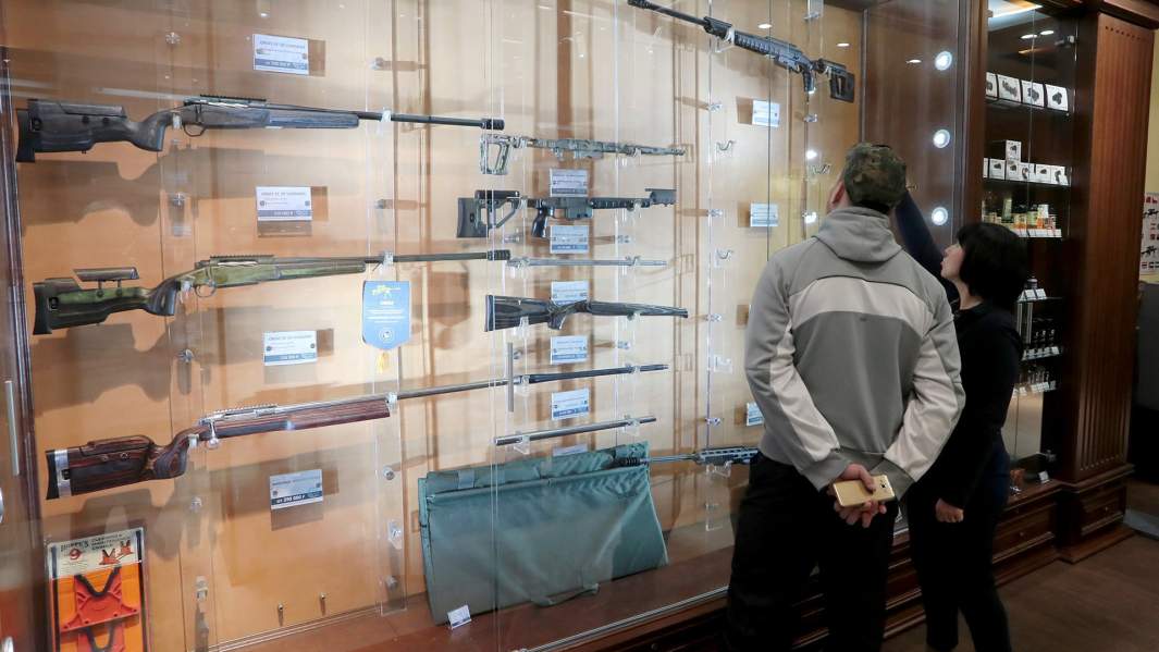 Покупатель рассматривает образцы оружия в оружейном магазине