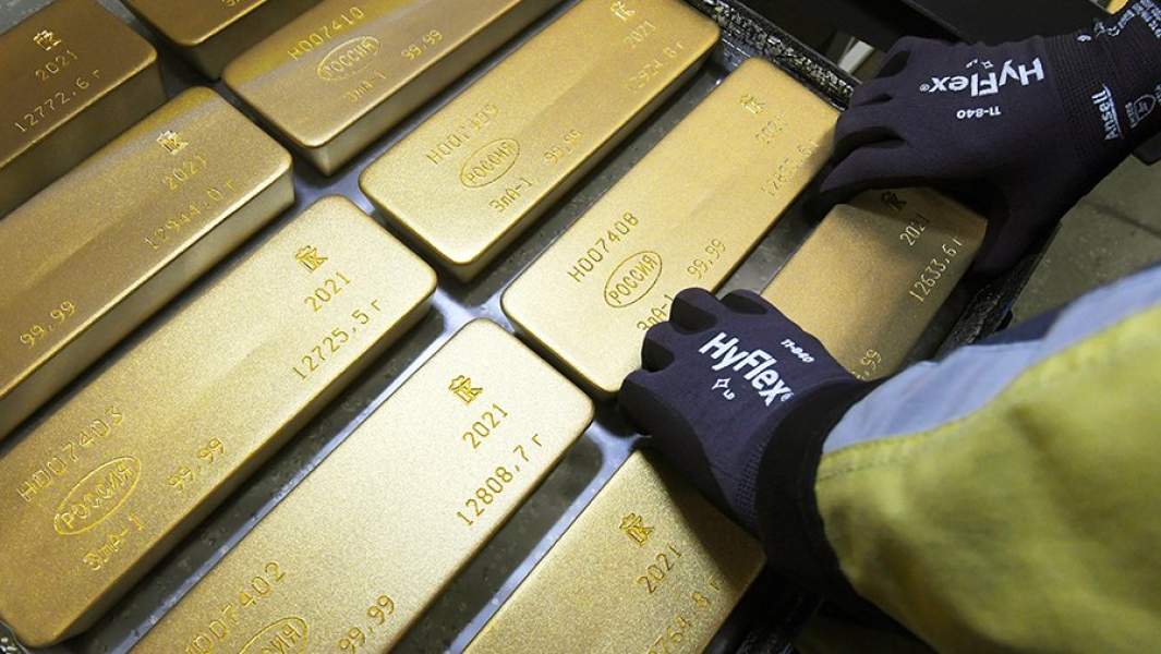 Сотрудник укладывает на тележку маркированные слитки золота высшей пробы 99,99 процентов чистоты