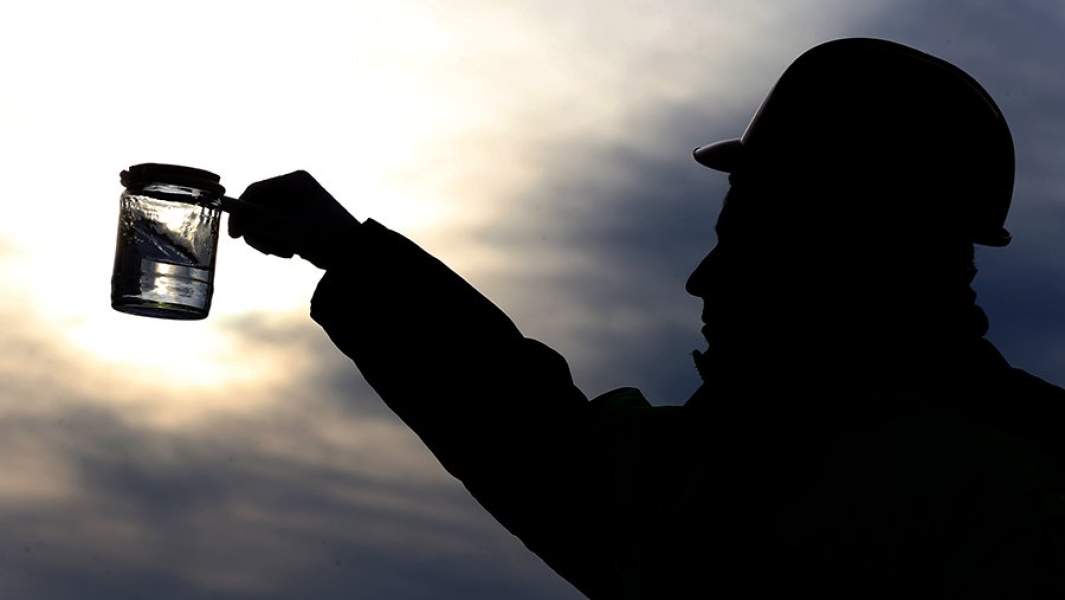 отрудник аэропорта Домодедово берет пробу авиатоплива в приемном резервуарном парке