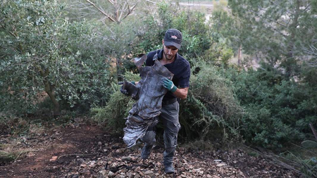 Израильская полиция собирает части ракеты, выпущенной из сектора Газа возле дома в деревне Бейт-Некуфа недалеко от Иерусалима