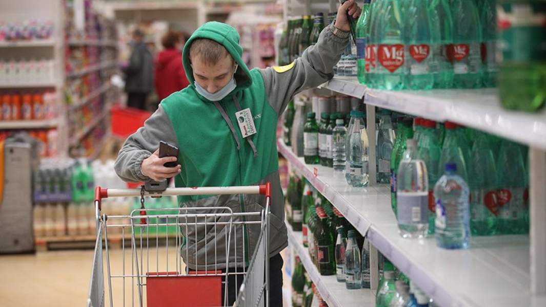 Работник службы доставки закупает продукты в супермаркете 