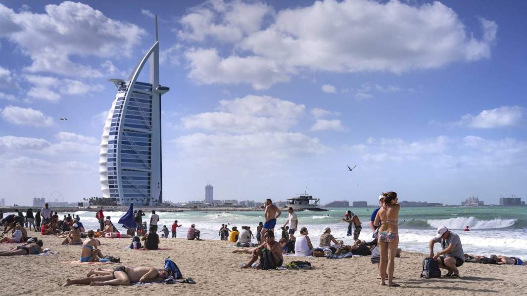 туристы на пляже в Эмиратах