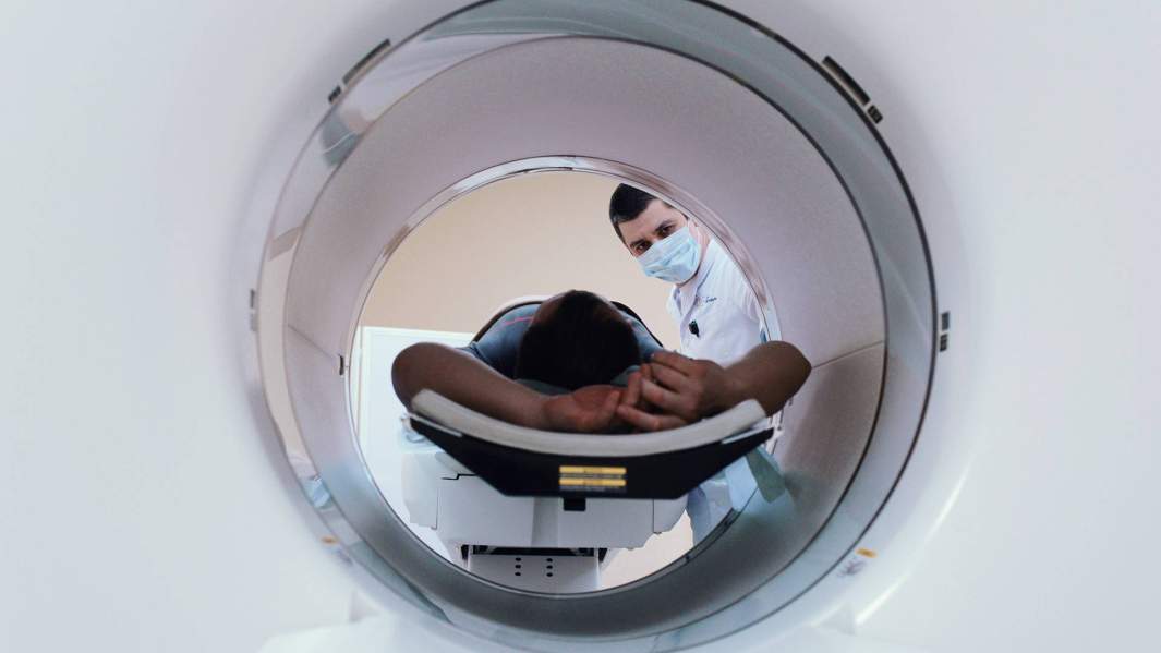 Врач-рентгенолог проводит обследование пациента на томографе