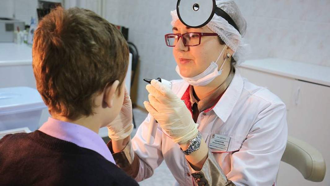 Врач-оториноларинголог осматривает пациента в детской поликлинике в Волгограде