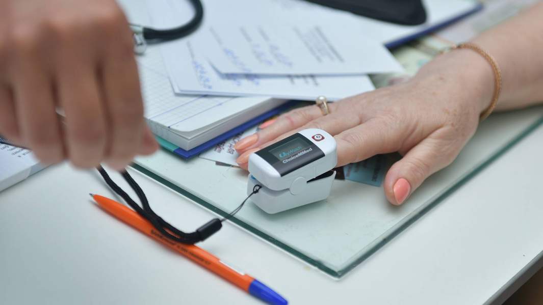 Медик замеряет сатурацию у женщины