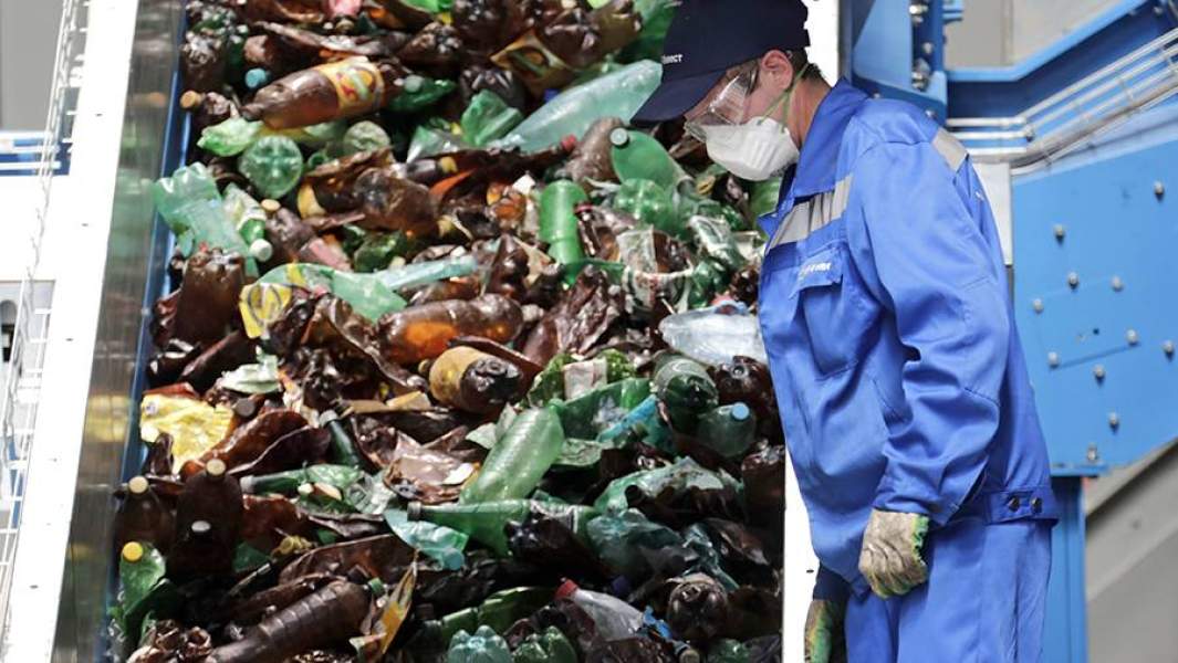 Сотрудник во время работы в сортировочном цехе в комплексе по переработке бытовых отходов