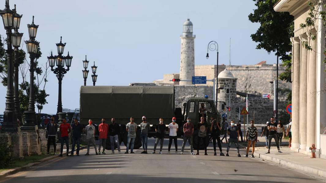 Полиция в штатском блокирует дорогу во время акции протеста против правительства