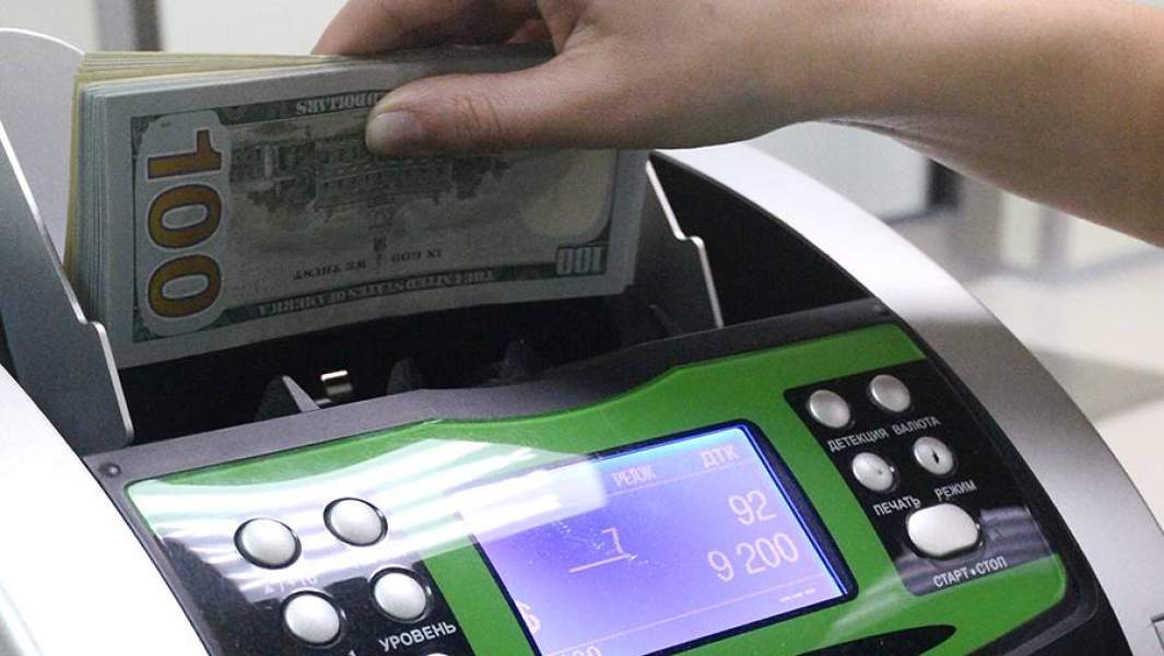 Доллары США в руках кассира