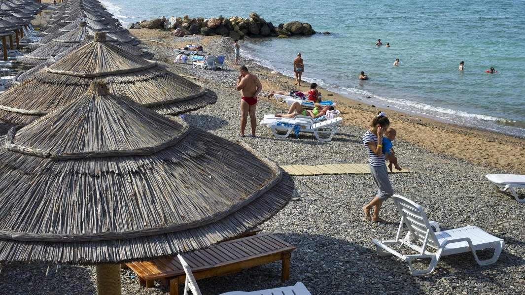 Отдыхающие на пляже семейного отеля у моря 