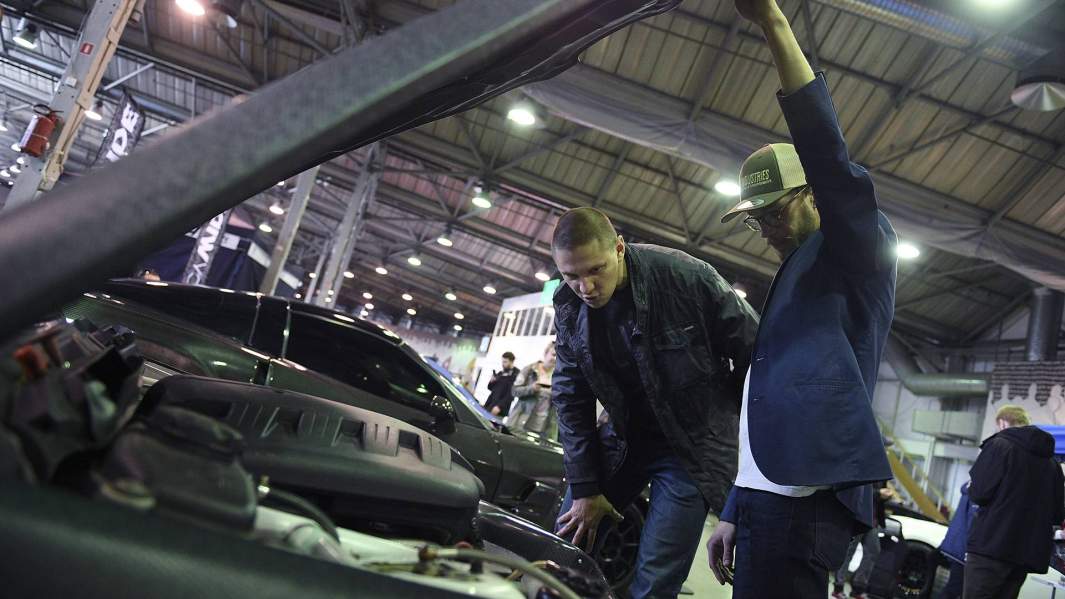 молодые люди заглядывают под капот машины