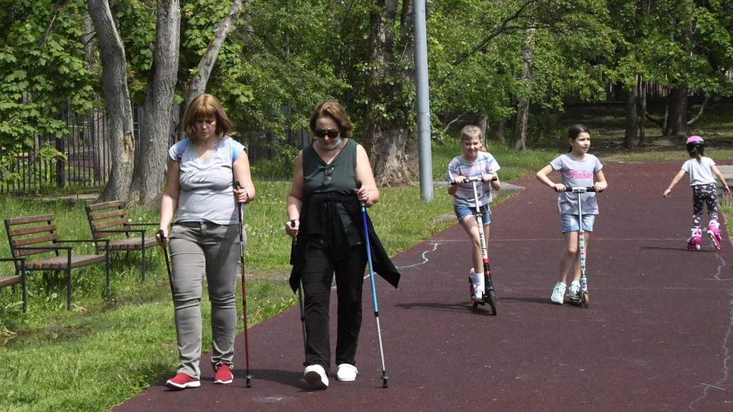 женщины занимаются скандинавской ходьбой в парке